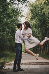 A guy and a girl are walking in the park. Romantic date evening walk. The relationship between people is love and tenderness.