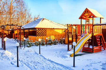 Yellow wooden gazebo in the yard on a Sunny winter day