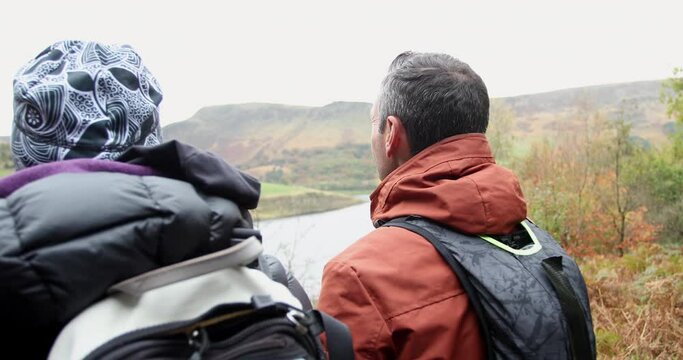 MS Rear view of two hikers sitting on bench in landscape / Yorkshire Moors, Yorkshire, UK
