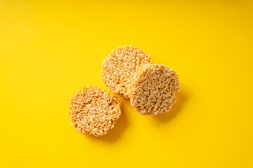 Three circle instant noodle over yellow background.