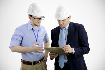 Head of project holds clipboard and discusses product details with chief engineer isolated on white background. Engineers reading instructions. Engineer and businessman meeting, team work