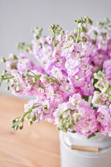 Bouquet of Beautiful lilac mattiola. Spring flowers in vase on wooden table. Flowers delivery.
