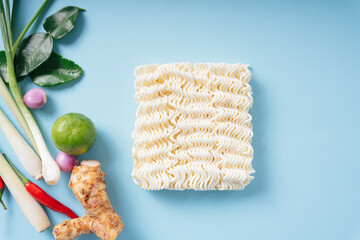Top view - Instant noodle with Tom Yum ingredients over blue background.