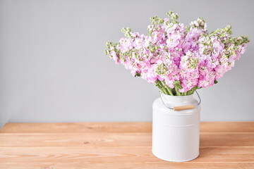 Bouquet of Beautiful lilac mattiola. Spring flowers in vase on wooden table. Flowers delivery.