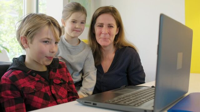 MS Mother and children (4-5) looking at laptop and laughing / Breda, Noord-Brabant, Netherlands