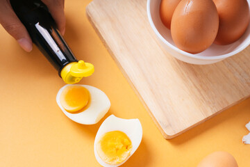 Delicious boiled egg and soy sauce on wooden plate.