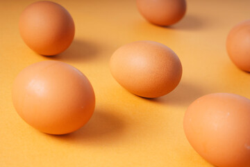 Organic fresh raw eggs over yellow background.