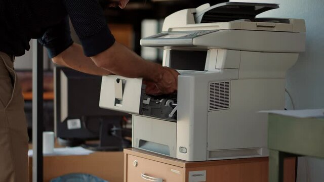 Man Finger Press Buttons On Multifunctional Copier.Man Using Printer Or Scanner In Office.Businessman Printing Document On Workplace.Businessman Working In Office And Preparing Documents For Signature