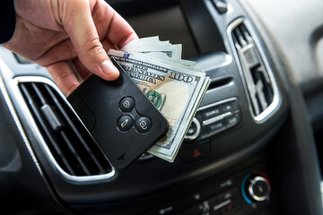 man hold dollar and car key for pay rent or bribe