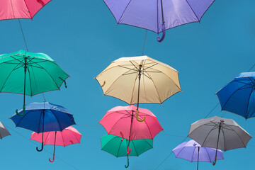 Fototapeta na wymiar Colorful umbrellas on the blue sky background. 