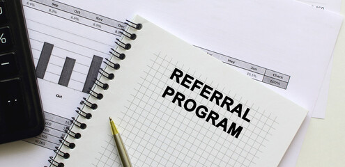 A notebook lies among the financial statements on the office desk. In the notebook, the inscription