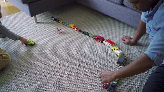 MS Father and son (2-3) playing with car toys in living room / Denmark