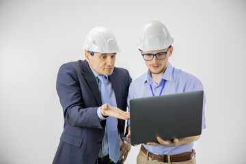 Unsatisfied head of project, chief engineer in hard hats discuss new project using laptop, calculating engineering decisions isolated on white background. Team discussion. BIM, Industry construction
