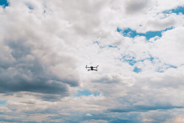 Fototapeta na wymiar Drone flying overhead in cloudy blue sky