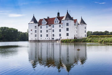 Fototapeta na wymiar Historic castle with reflection in the lake in Glucksburg, Germany