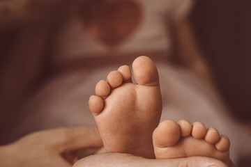 children's feet in the hands of parents