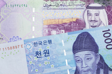 A blue two thousand won note from South Korea close up in macro with a five riyal note from Saudi Arabia
