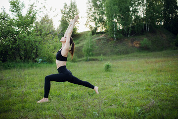 Obraz na płótnie Canvas a sporty girl does yoga in the Park. Outdoor sports activities