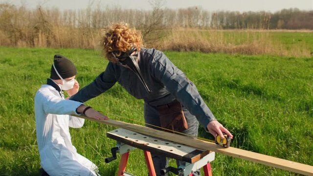 MS People wearing protective suits and masks distancing in grassy field / Prinsenbeek, Noord-Brabant, Netherlands