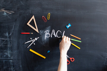 Back to school concept. Chalkboard background. Hand and education tools. 