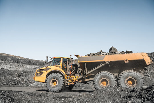 Large quarry dump truck. Loading the rock in dumper. Loading coal into body truck. Production useful minerals. Mining truck mining machinery, to transport coal from open-pit excavator work