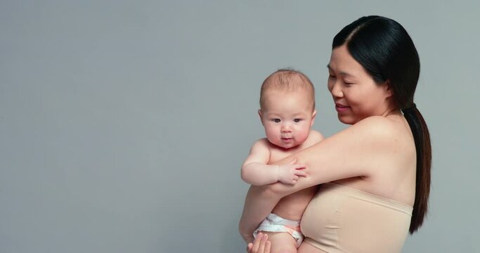 SLO MO MS Studio shot of woman holding baby son (6-11 months)