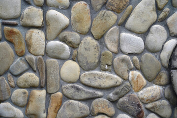 The wall is made of river stone and cement
