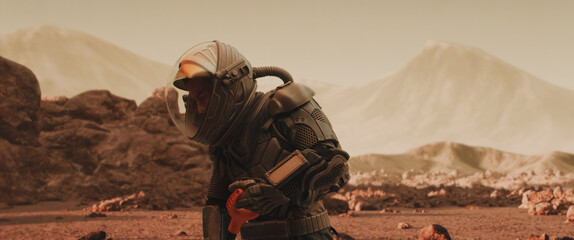 Caucasian male astronaunt in a space suit gathering materials on a planet surface, Mars colonization concept © supamotion