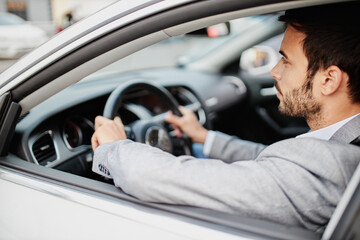 Side view of a young man driving a car