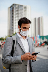 Young man wearing a face mask using phone