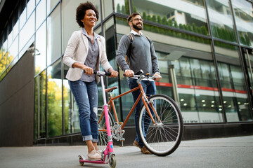 Happy couple using electric scooter, bicycle in city. Green eco energy concept with zero emission