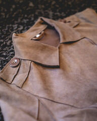 Close-up of brown eco leather jacket over black hairy background 