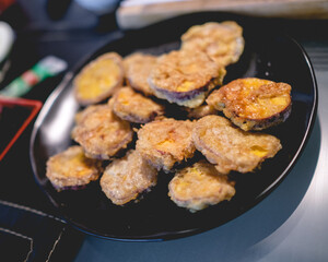 Homemade fried breaded sweet potato snacks on a black plate