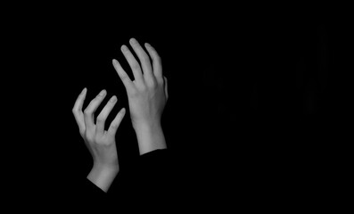 Female white hands covering a nonexistent face on a black isolated background. Close-up, gestures,...