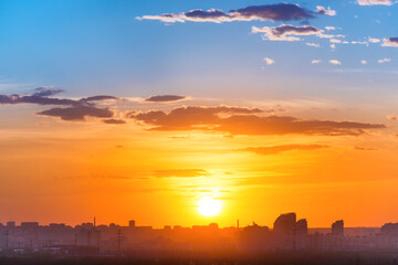 Sunset in big city, landscape with dramatic sky, clouds and sun rays