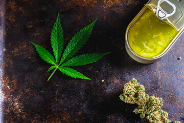 marijuana buds. medical cannabis butter in a open tin can. hemp leaves. horizontal orientation.