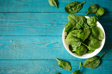 Fresh spinach leaves on a blue table
