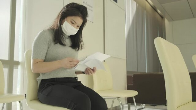 sick asian female face mask protection cough and sneeze with high temperature headache feel bad corona virus covid 19 infected sit wait at hospital clinic waiting area