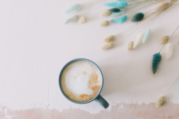 Coffee cup with dried flowers. Breakfast flatlay with big mug of milky cappuccino coffee and flowers. Rustic style. Good morning