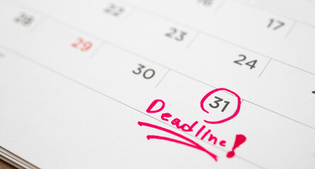 Deadline write on white calendar page date close up