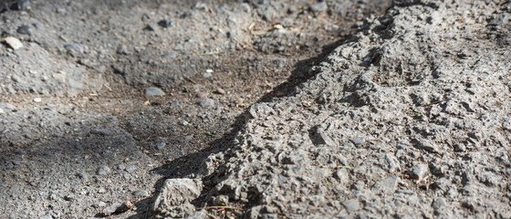 Broken asphalt is close-up, soft focus