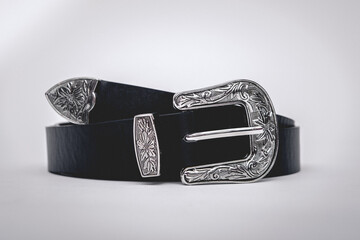 Black eco-leather belt with silver metal buckle in white background 