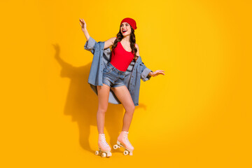 Obraz premium Full size photo of cheerful funky teen youth student girl enjoy spring free time weekend roller skated ride wear red headwear jeans singlet isolated over bright color background