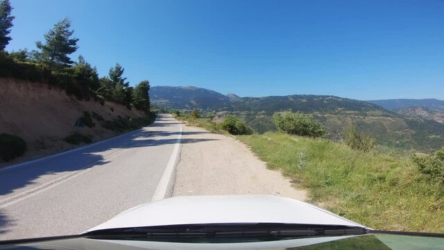 Pull over on a mountain road. Driver POV of a white car pulling over to the side of the road in a European countryside.