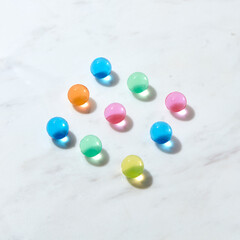 Diagonal pattern from hydrogel color balls on a grey marble table.