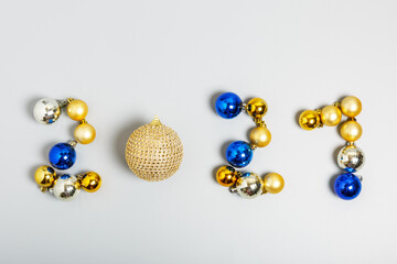 numbers 2021 made of gold, silver and blue Christmas balls on a gray background. New Year 2021 celebration concept. top view, flat lay