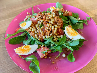 Salad of arugula, tuna, tomato, eggs and pine nuts