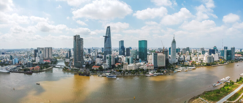 Aerial view of Bitexco Financial Tower building, train tracks, buildings, roads, and Saigon river in Ho Chi Minh city. High quality panorama image