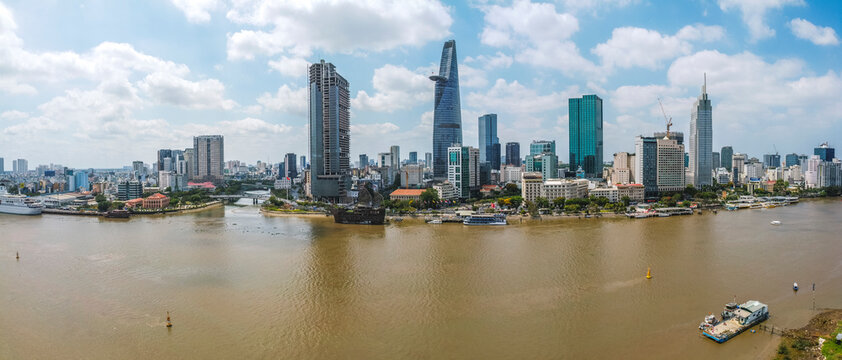 Aerial view of Bitexco Financial Tower building, train tracks, buildings, roads, and Saigon river in Ho Chi Minh city. High quality panorama image