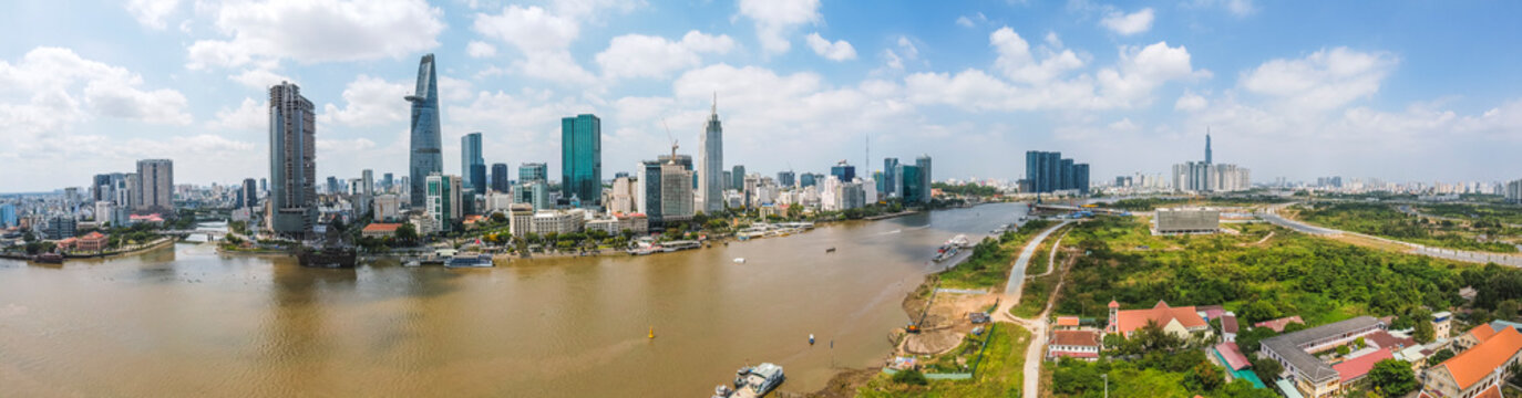 Aerial view of Bitexco Financial Tower building, train tracks, buildings, roads, and Saigon river in Ho Chi Minh city. High quality panorama image